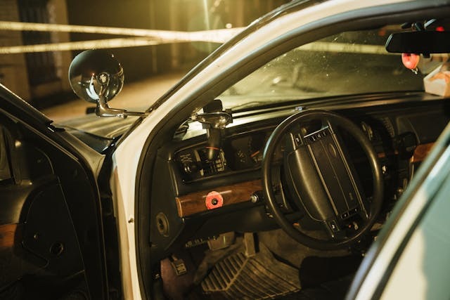 Старата полицейска кола с интериор в нощта, оборудвана с сиренa и контролни панели.