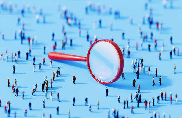 Миниатюрни фигури под увеличително стъкло, изследващи взаимодействия в обществото.