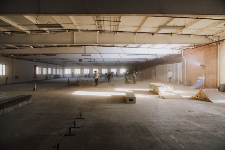 Спортна колективна сесия в закрит скейт парк, пълен с уличен стил и ентусиазъм.