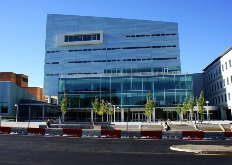 Модерна многоетажна сграда с стъклен фасад, част от университетски кампус.