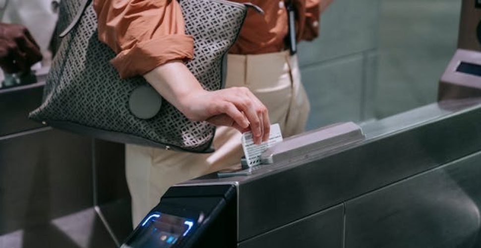 Жена В Проверка На Билет В Градски Транспорт Жена проверява билет в модерен транспортен терминал, демонстрирайки градска мобилност.