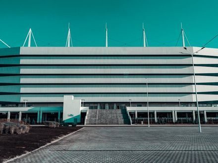 Модерен Стадион с Минималистичен Дизайн Модерен стадион с минималистичен дизайн и елегантна бяла фасада под синьо небе.