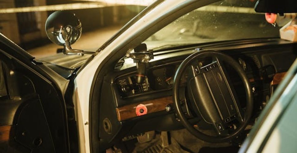 Старата полицейска кола с интериор в нощта, оборудвана с сиренa и контролни панели.