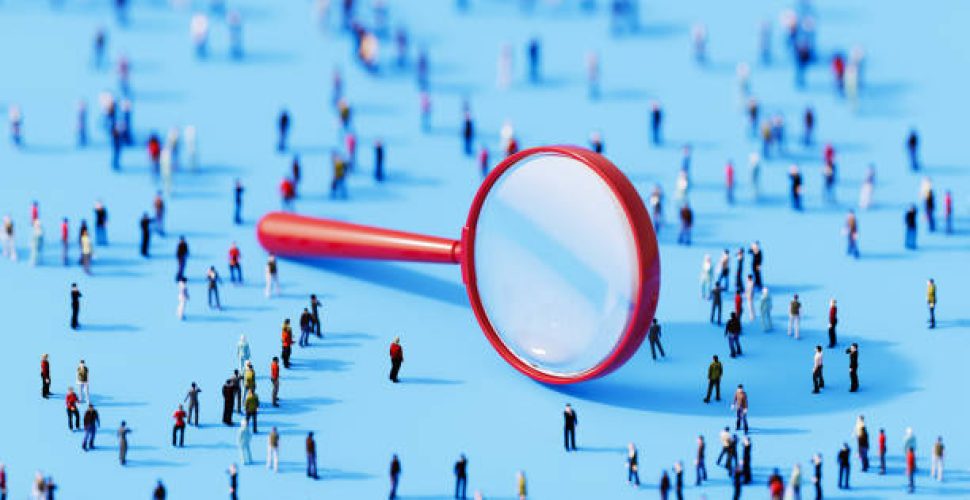 Миниатюрни фигури под увеличително стъкло, изследващи взаимодействия в обществото.