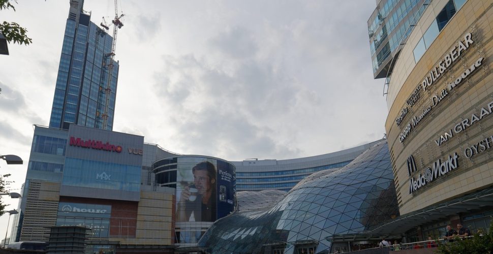 Модерна архитектура на търговски център с кино и заведения за хранене.